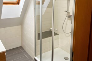 A glass-enclosed shower with a built-in shelf, white tiled walls, and a skylight. - Apartment 'Ferienwohnung 3, 70 Qm' with Shared Garden, Balcony and Wi-Fi (Owingen)