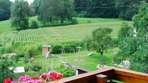 A view of a lush green landscape with a playground, a small wooden structure, and a bench. - Apartment 'Ferienwohnung 3, 70 Qm' with Shared Garden, Balcony and Wi-Fi (Owingen)