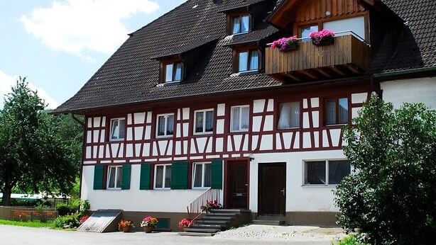 A traditional half-timbered building with a balcony, a staircase, and a door. - Apartment 'Ferienwohnung 3, 70 Qm' with Shared Garden, Balcony and Wi-Fi (Owingen)