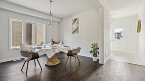 A dining area with a round table, two chairs, a chandelier, and a potted plant. - Amazing stay near Hamilton-Brantford- Beach Port Dover (Norfolk)