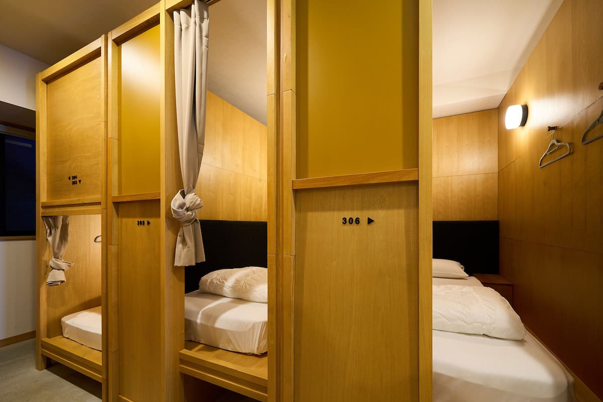 A hotel room with three wooden bunk beds, each with a number on the side.