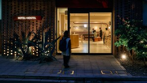 A hotel entrance with a sign reading "HOTEL+HOSTEL" and a visible interior with a pool table and people. - Hotel Plus Hostel TOKYO ASAKUSA 2 (Tokyo)