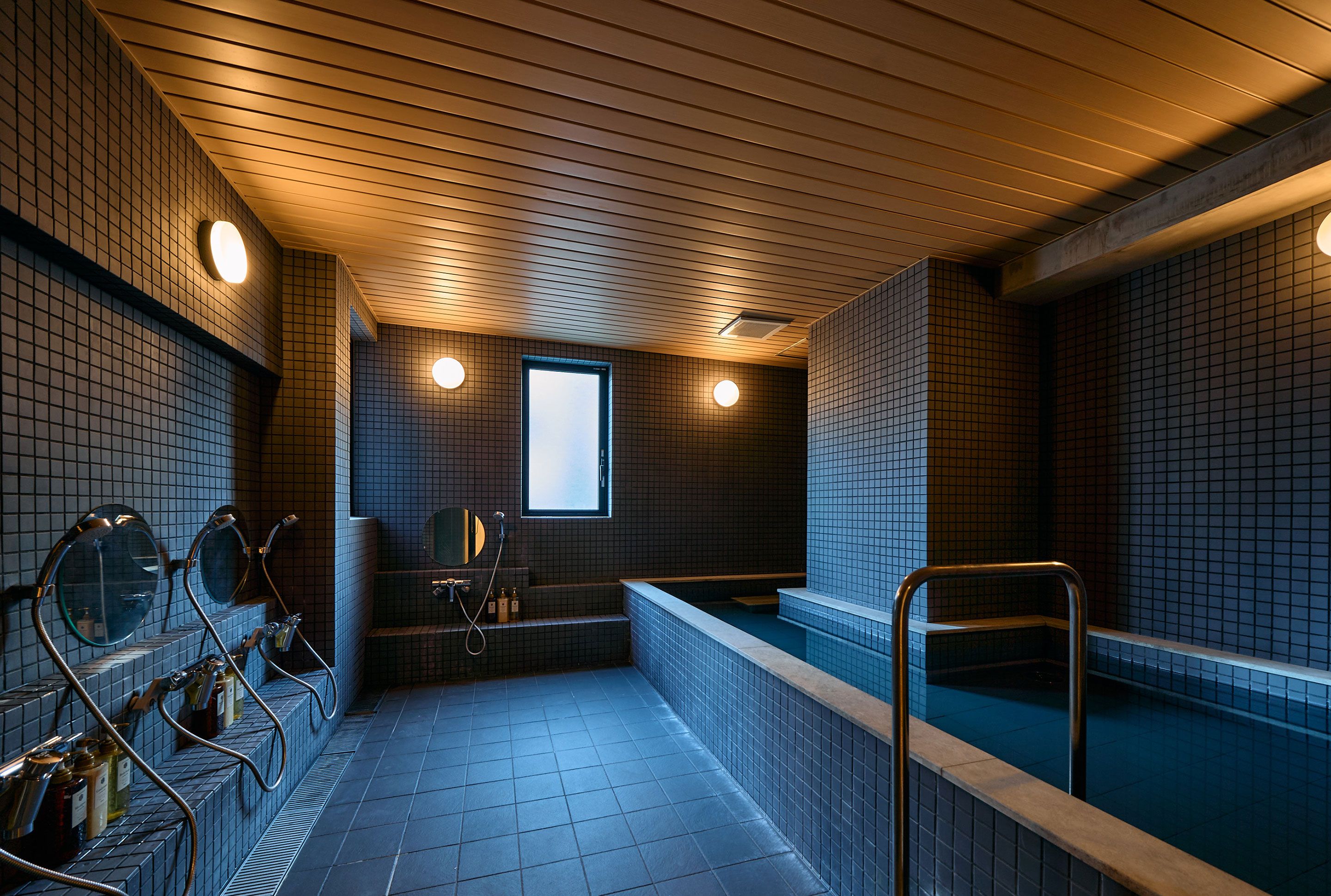 Uma sauna pública com vários bancos e uma área central de hidromassagem.