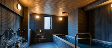 A public sauna with multiple benches and a central hot tub area.