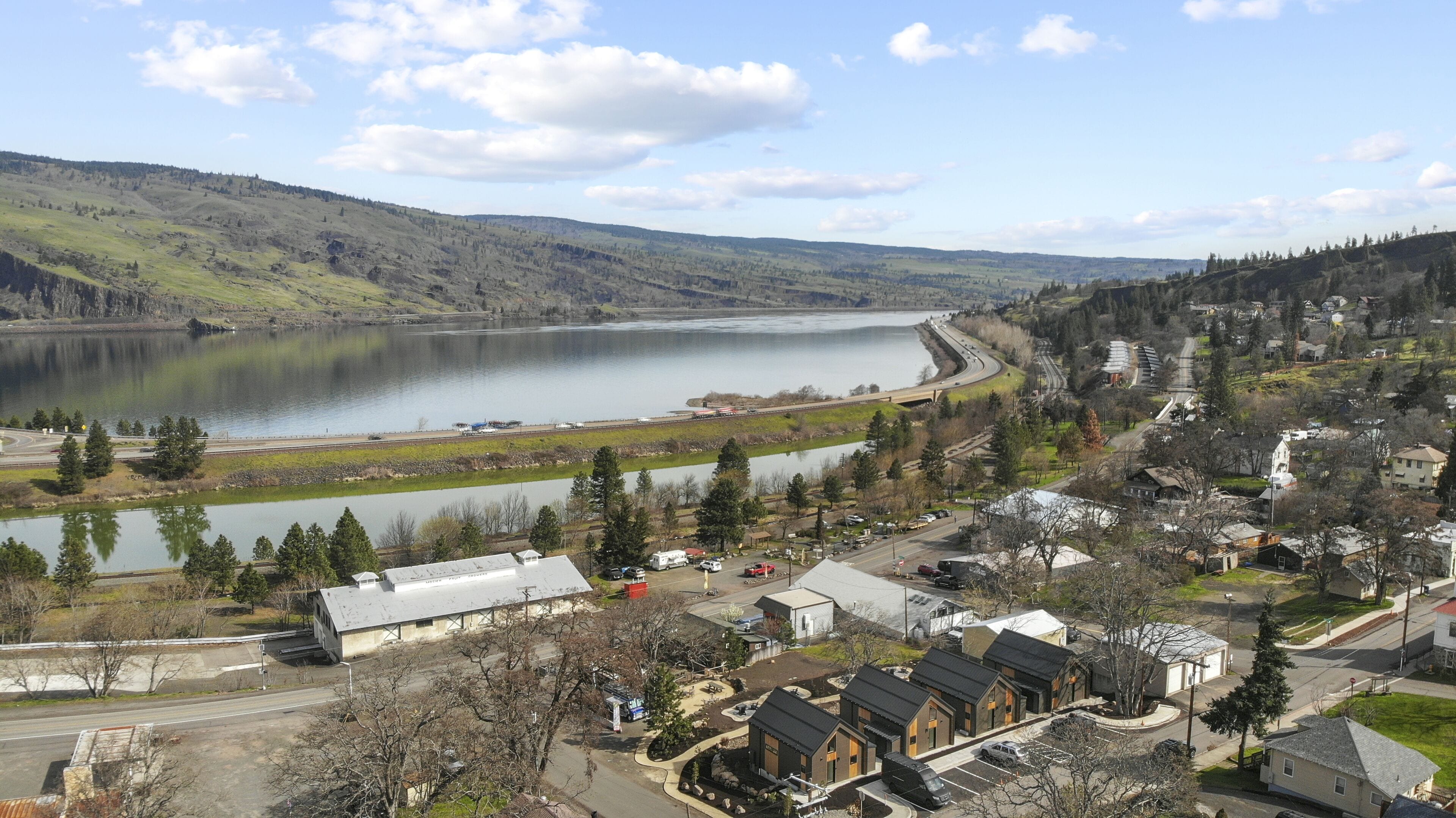 Une ville située au bord d’un lac, où se côtoient des immeubles résidentiels et des bâtiments commerciaux, un pont et une voie ferrée.