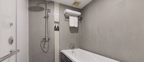 A modern bathroom with a walk-in shower, a bathtub, and a towel rack.
