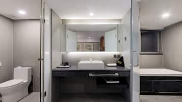 A modern bathroom with a glass-enclosed shower, a white sink, and a bathtub.