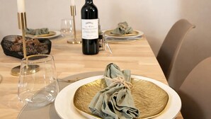 A dining table with a bottle of wine, candles, and a plate with a cloth. - Unique Parisian flat near Gare Montparnasse (Paris)