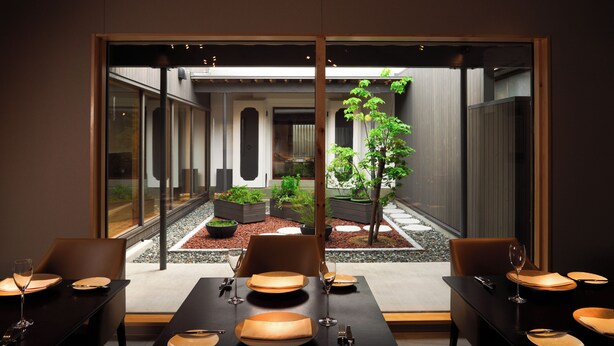 A modern dining area with a view of a courtyard. - Auberge Homachi Mikuniminato (Sakai)