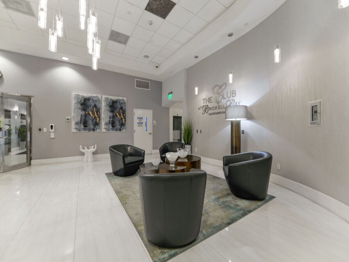 A modern lobby with a clean, minimalist design, featuring a reception desk, comfortable seating, and contemporary artwork on the walls.