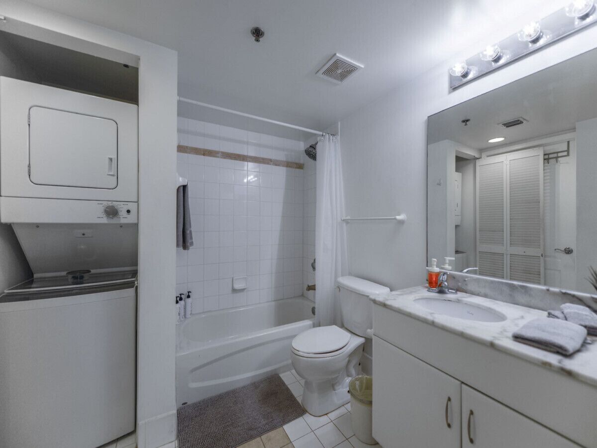 A bathroom with a toilet, sink, and shower.