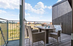 Enjoy a serene view of the surrounding countryside from this balcony, featuring a table and chairs.