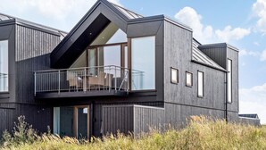 A modern house with a balcony, large windows, and a sloped roof. - Beautiful home in Skagen with WiFi (Skagen)