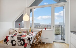 Enjoy meals in this serene dining area with a view, featuring a table set for four and a stylish tablecloth.