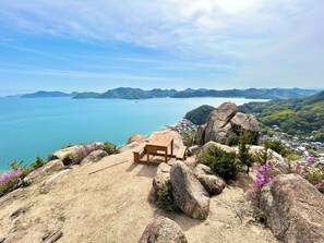 A wooden bench on a rocky outcrop overlooking a coastal area with mountains in the distance. - 10seconds From the Beautiful sea in Front. Enjoy Bbq, Cycling, Sup With Dogs (Onomichi)