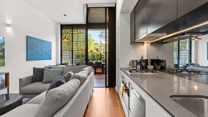 Eine moderne Küche mit Einbauofen und Essbereich inklusive Sofa und Tisch.