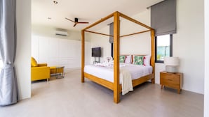 Une chambre à coucher moderne avec un lit à baldaquin, un canapé jaune et une table de chevet avec une lampe.