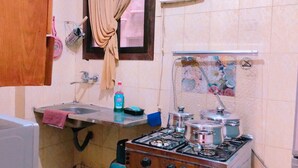 Una cocina funcional con lavamanos, estufa a gas y una pequeña encimera.