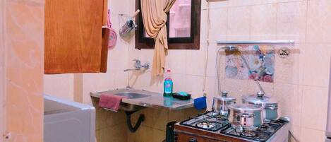 A compact kitchen with a sink, a gas stove, and a small countertop.