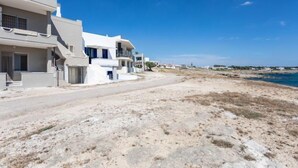 A coastal residential area with modern white buildings, sandy terrain, and a clear blue sky. - Vacation home Enrica by Interhome (Marina di Mancaversa)