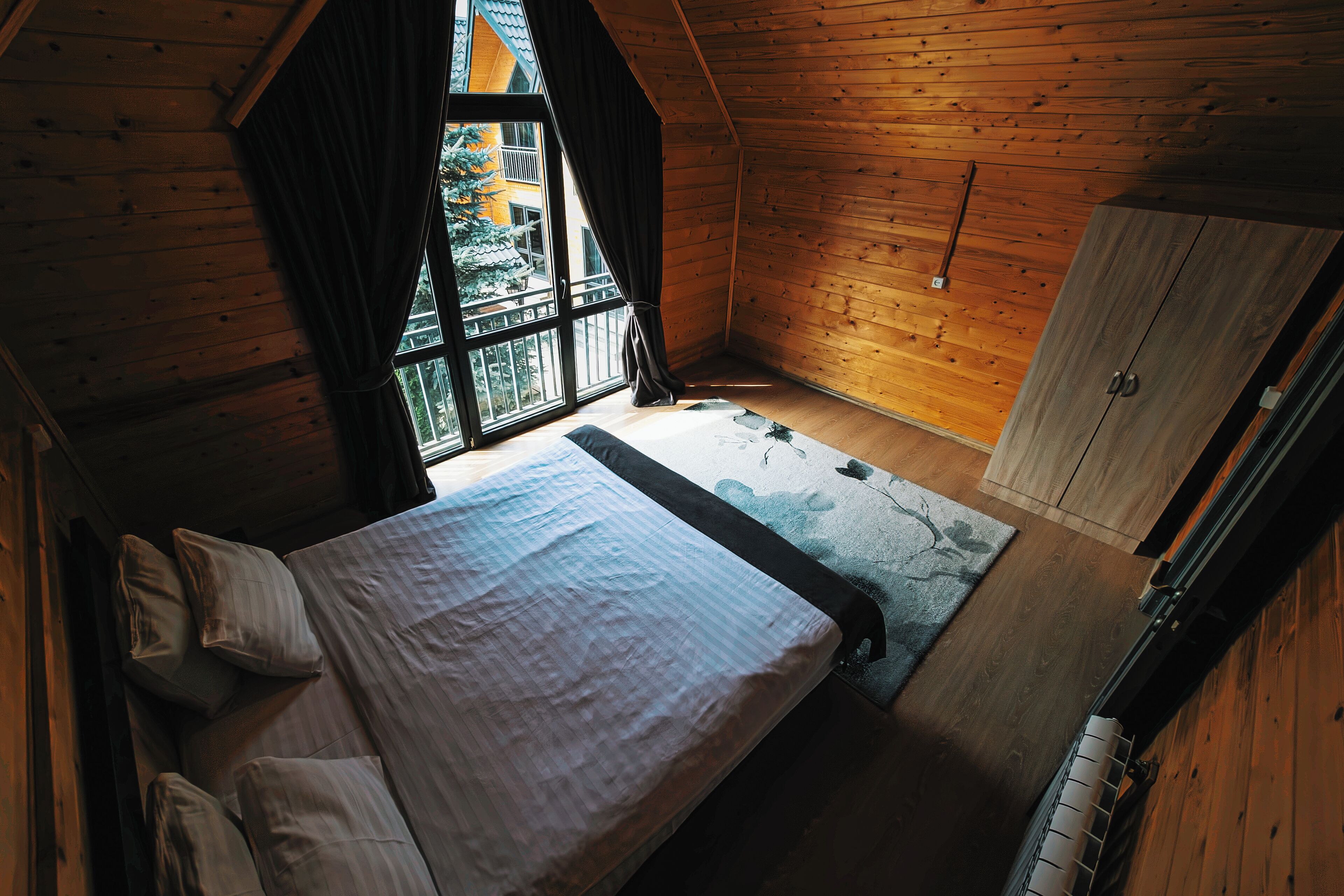 Um quarto com uma cama, uma janela e um guarda-roupa.