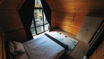Um quarto com uma cama, uma janela e um guarda-roupa.