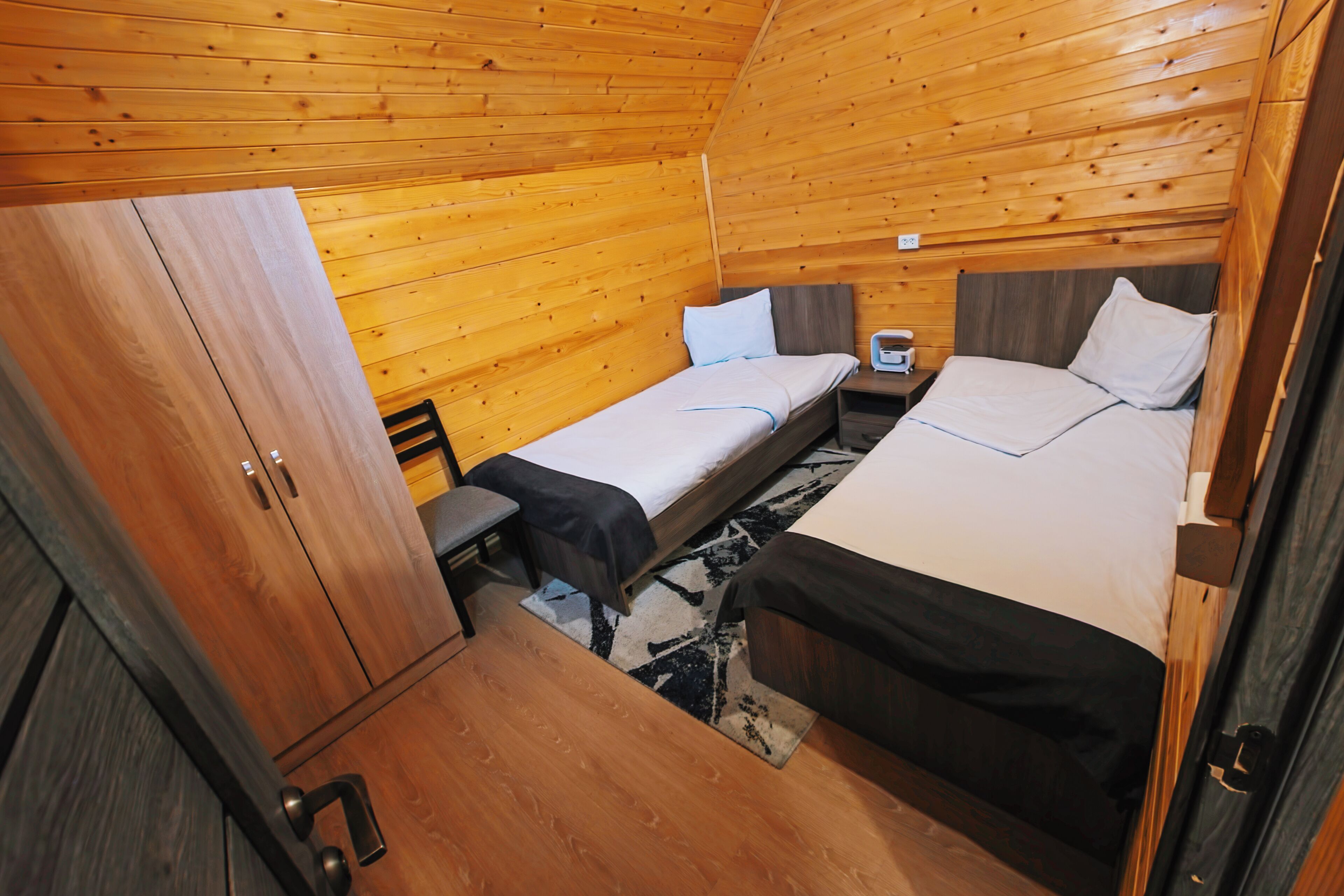 Uma cabine compacta com duas camas, uma mesa pequena e um armário.