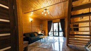A wooden interior with a sofa, coffee table, and a staircase.
