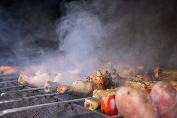 A grill with various meats and vegetables being cooked. - Everest Rest House (Tsaghkadzor)