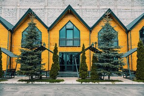 A yellow wooden building with a symmetrical facade, multiple windows, and a central entrance. - Everest Rest House (Tsaghkadzor)
