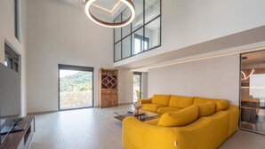 A spacious living area with a large sofa, a television, and a wooden cabinet. - Seaview Villa with pool Vanja (Podostrog)