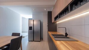 A modern kitchen with a wooden countertop, stainless steel appliances, and a built-in wine rack. - Seaview Villa with pool Vanja (Podostrog)