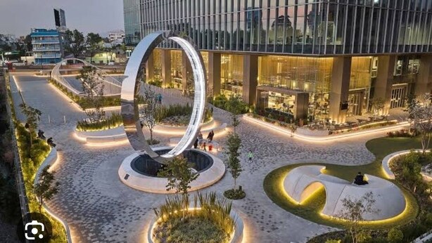 A modern building with a circular glass facade, landscaped courtyards, and a central spiral staircase.