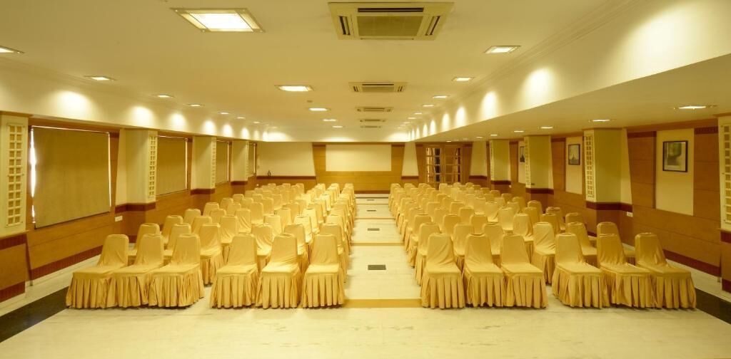A large conference room with rows of chairs and a stage at the front.