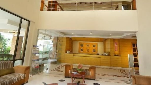 A spacious lobby with a central coffee table, a chandelier, and a patterned floor. - HOTEL PLAZA INN (Coimbatore)
