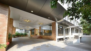 A modern hotel lobby with a spacious entrance, a staircase, and a glass facade. - HOTEL PLAZA INN (Coimbatore)