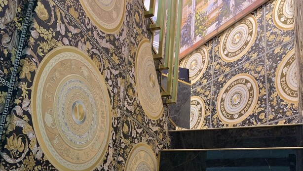 Un escalier orné de motifs circulaires complexes et dont les marches sont en marbre noir.