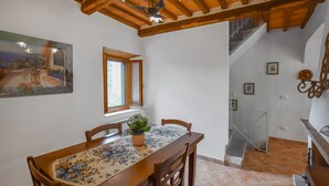 A dining area with a wooden table and chairs, a window with a view, and a staircase leading to another level. - Cozy home in Limano with WiFi (Limano)
