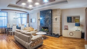 A modern living room with a sofa, coffee table, and fireplace. - HB apartments Besik (Tbilisi)