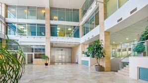 A spacious atrium with a high ceiling, multiple levels, and large windows allowing natural light. - HB apartments Besik (Tbilisi)