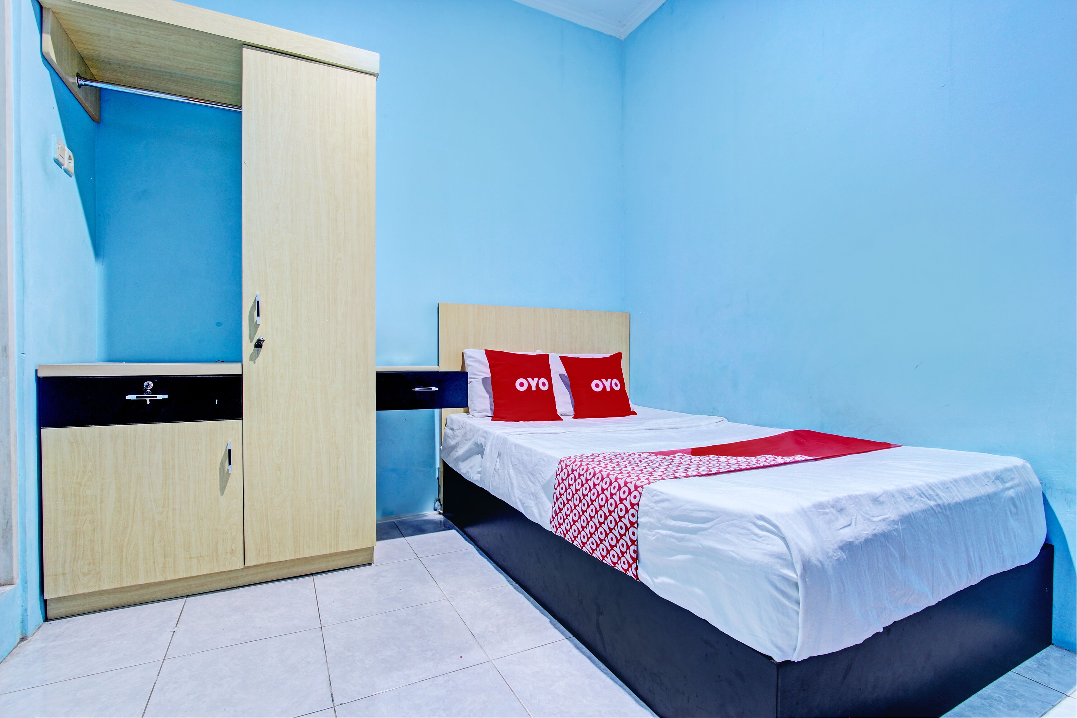 Une chambre à coucher avec un lit, une armoire et un petit bureau.