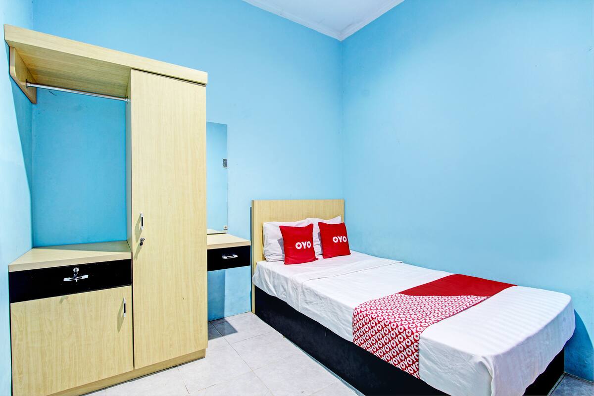 Une chambre avec un lit, une armoire et un bureau.