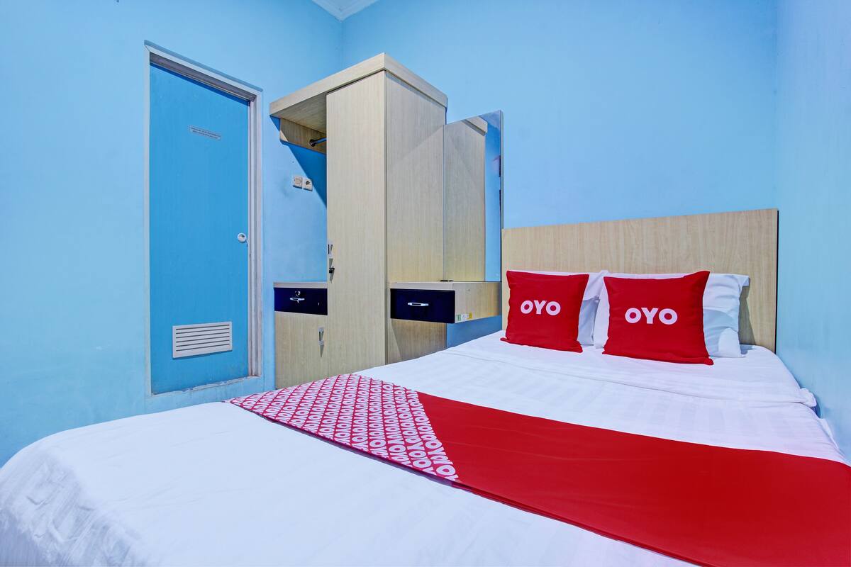 Une chambre d’hôtel avec un lit, une armoire et une porte.
