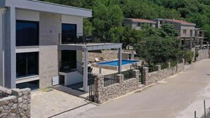 A modern two-story building with a stone wall and a swimming pool. - Seaview Villa with pool Hanja (Podostrog)