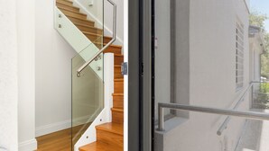 A modern staircase with glass railings and wooden steps.