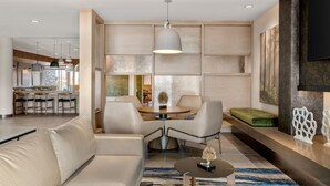 Un salon moderne comprenant un canapé, une table basse et un coin repas avec des chaises et une table.