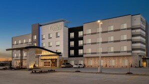 Un hôtel Fairfield by Marriott au design moderne, caractérisé par une façade en pierre, de nombreux étages et une entrée bien éclairée.