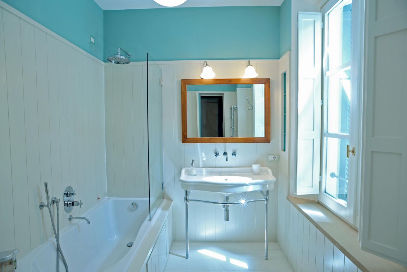 Une salle de bain avec une baignoire, un lavabo et un miroir.