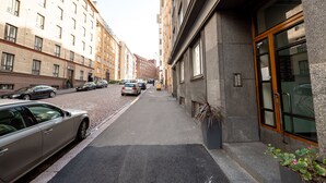 A narrow street with parked cars and buildings on both sides. - 2ndhomes Charming and Cozy 1BR Apartment (Helsinki)