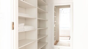 A walk-in closet with multiple shelves and a door leading to a balcony. - 2ndhomes Charming and Cozy 1BR Apartment (Helsinki)